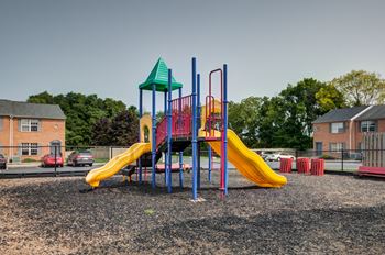 a playground with a yellow slide and a red and blue slide
